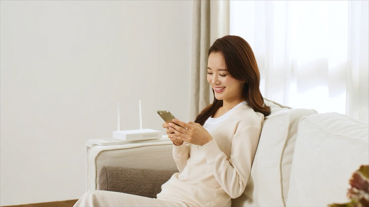 설치를 마친 거실 소파에서 휴대폰으로 입금을 확인하는 여성