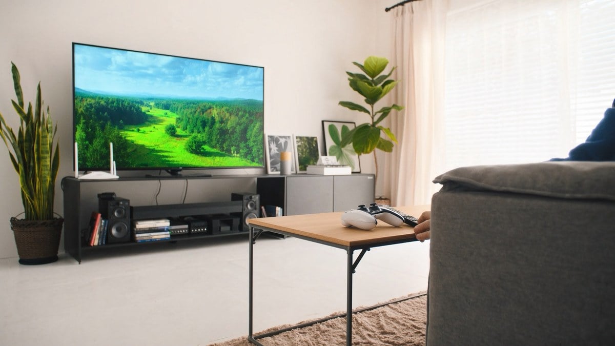 숲 풍경 TV 앞 탁자 위 게임 패드와 리모컨