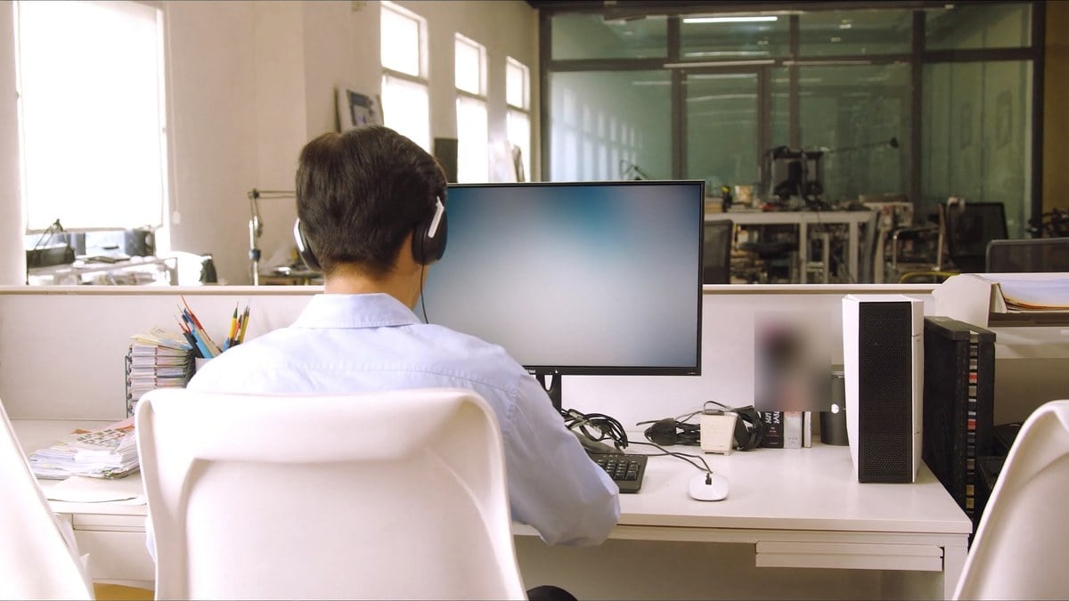헤드폰을 쓰고 PC 게임을 하는 남성