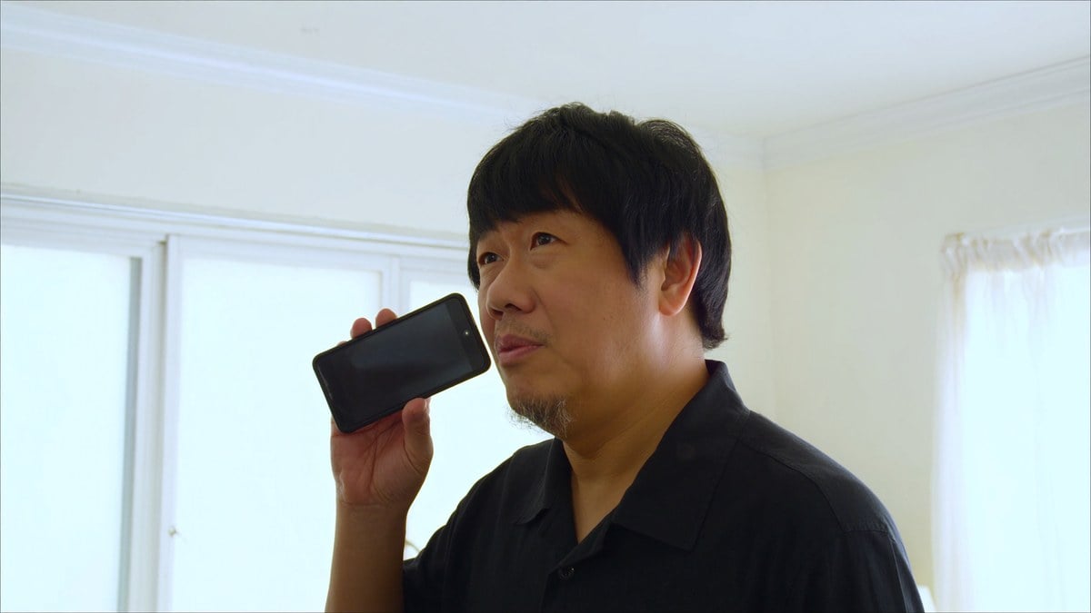 식탁에서 휴대폰을 의심스럽게 보는 남성