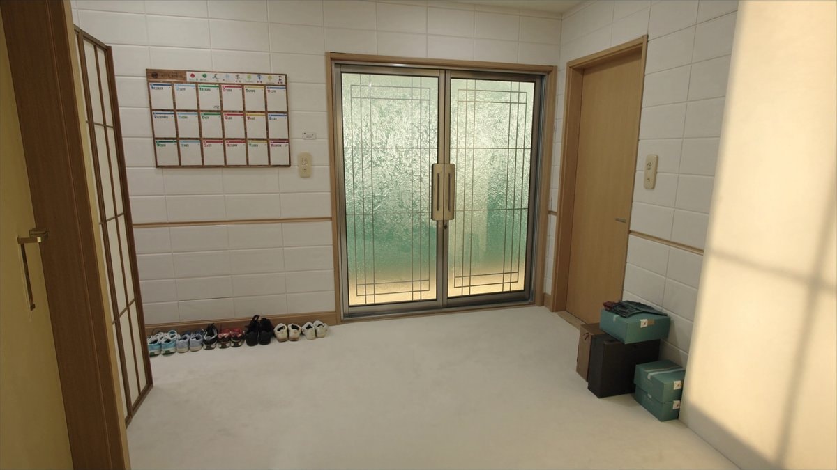 신발 여러 켤레와 벽걸이 달력이 있는 현관