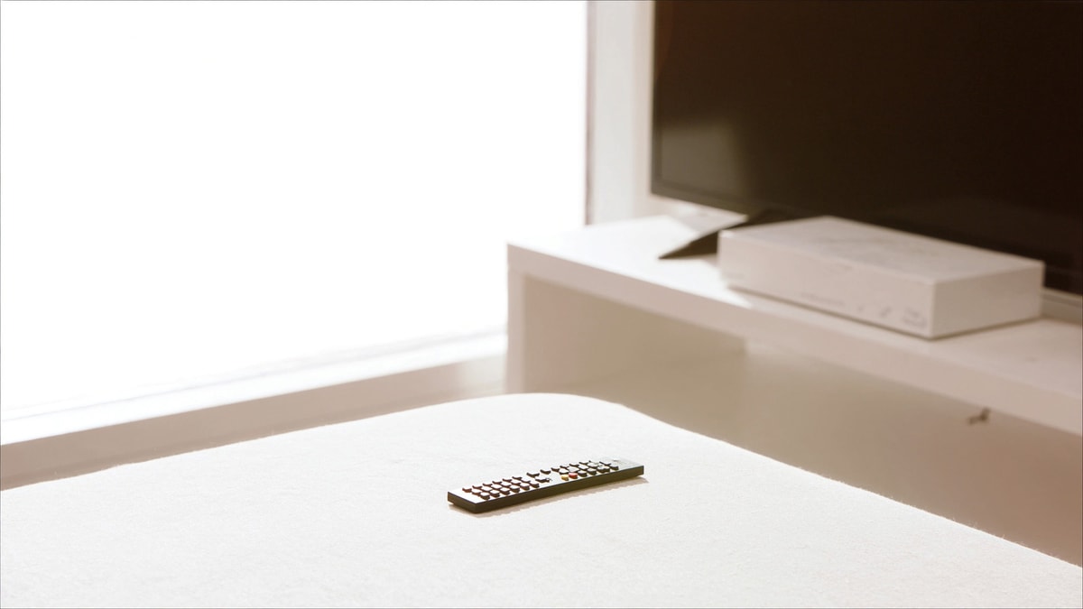 소파 위 TV 리모컨과 거실장 위 셋톱박스