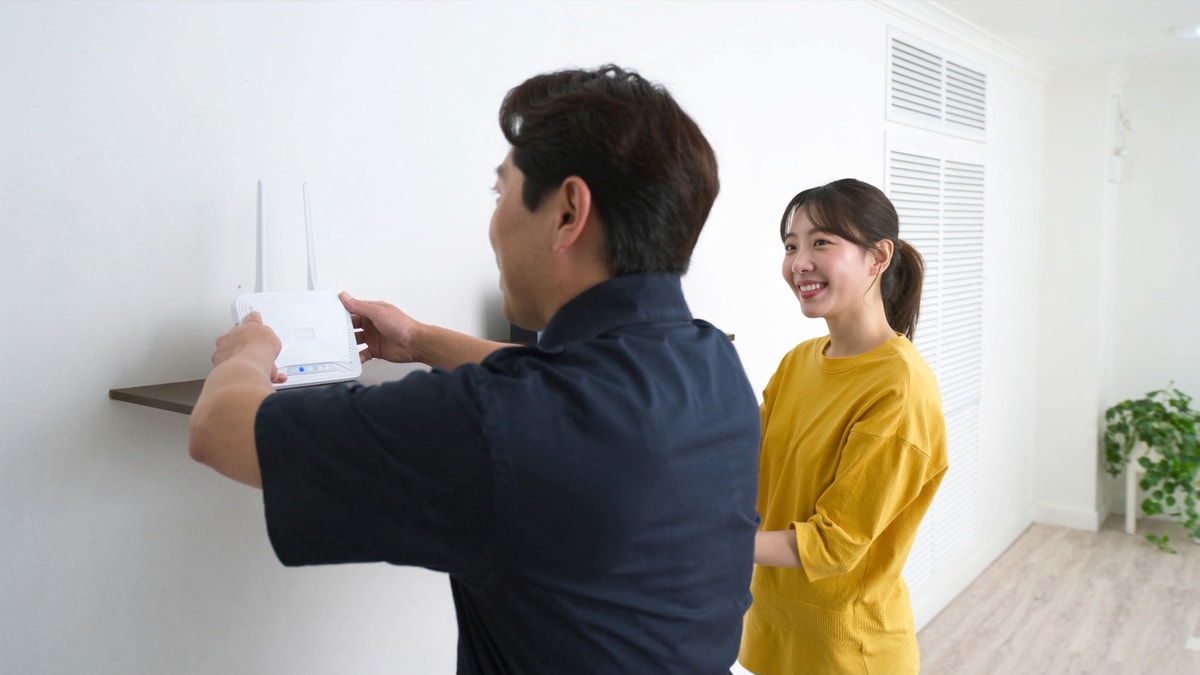 설치 기사가 공유기를 설치하고 거주자가 지켜보는 모습